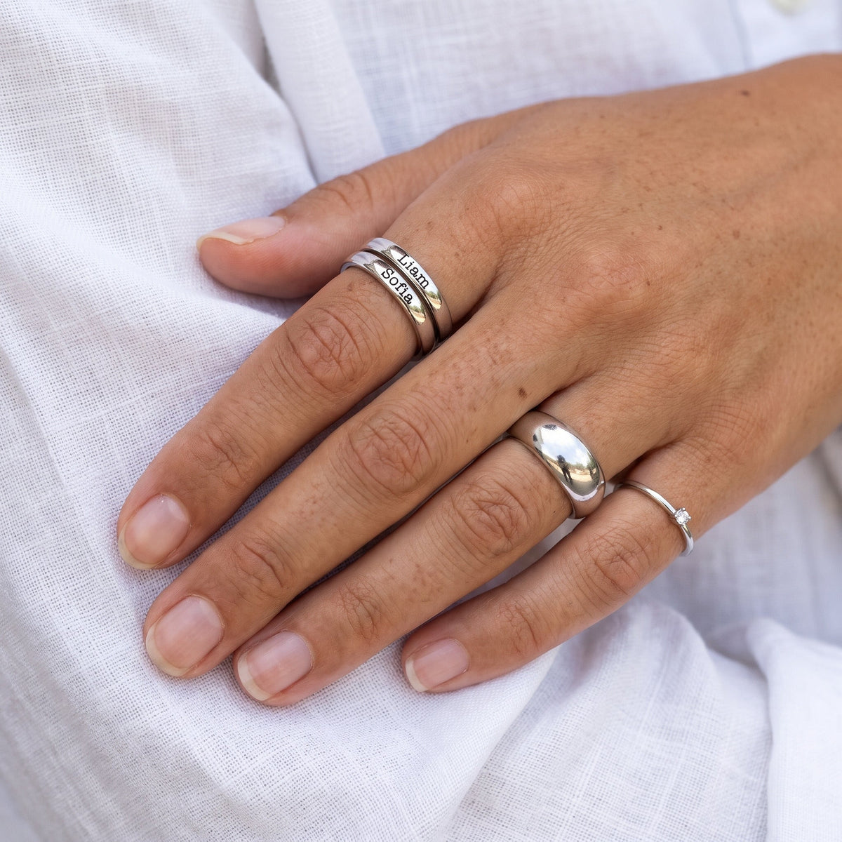 Tunn stapelbar namnring – silver – kombinerad med andra ringar, buren, närbild