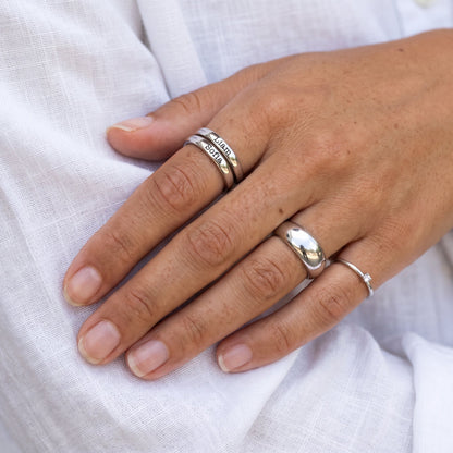 Tunn stapelbar namnring – silver – kombinerad med andra ringar, buren, närbild